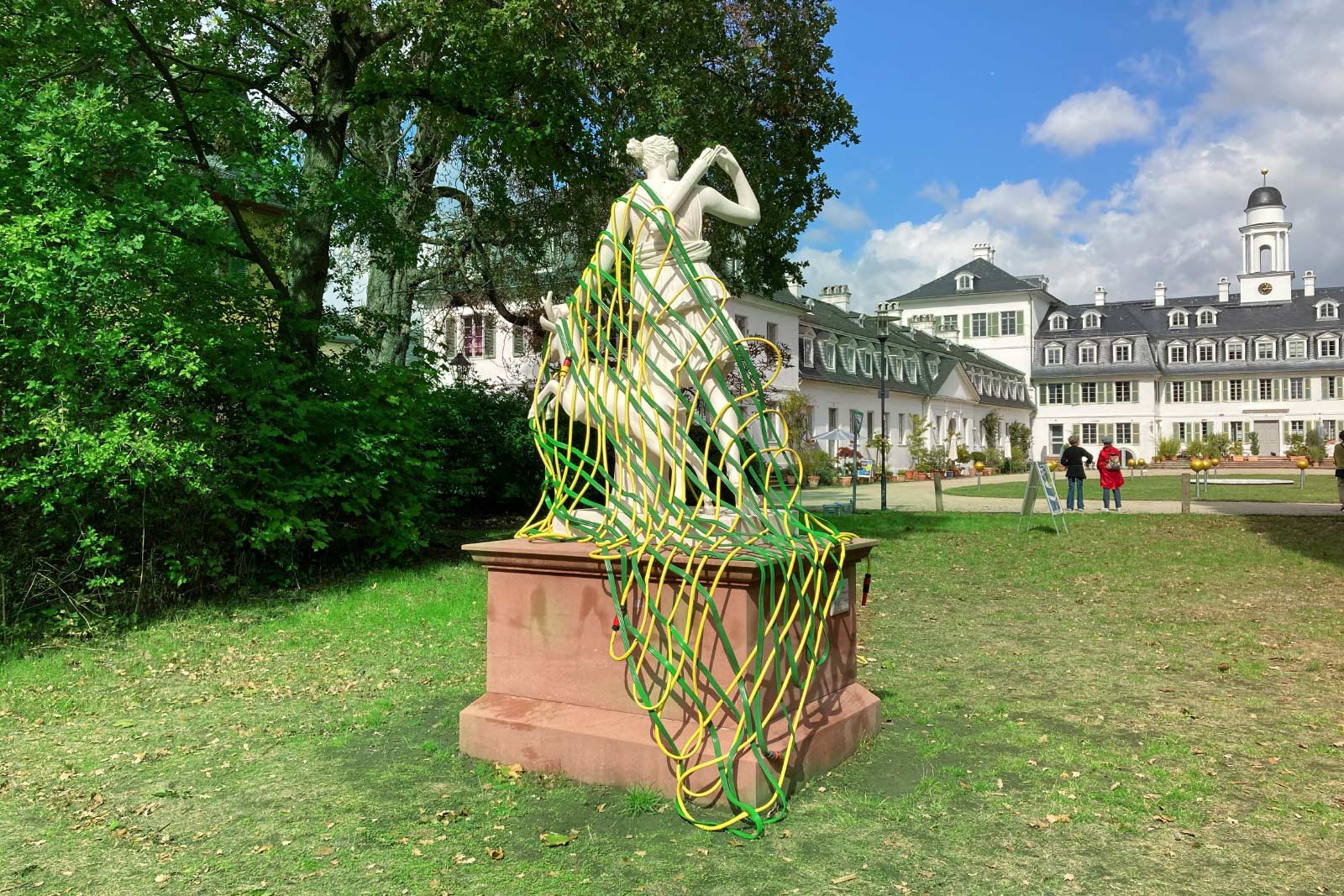 Kunst-Installation von Josephine Riemann: ein aus Gartenschlauch gewebtes Netz, welches einer Plastik der Göttin Diana (im Schlosspark Rumpenheim, Offenbach bei Frankfurt am Main) umgelegt wurde.