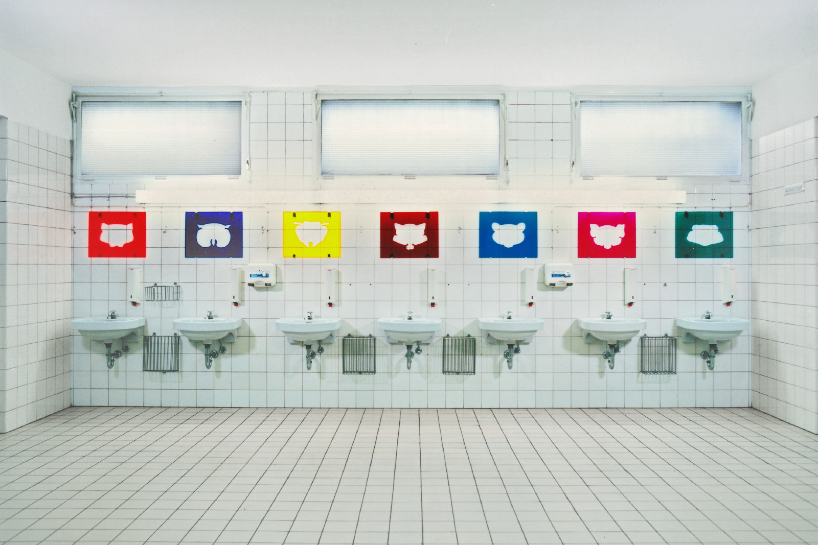 Spiegelbilder,
1992 | Installationen für eine Wand über Waschbecken
verschiedenfarbiges Acrylglas, Spiegelhalter