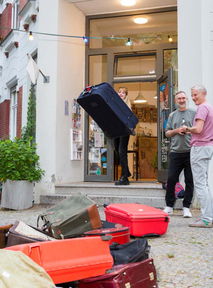 Kunst-Aktion von Josephine Riemann (Detail): Teilnehmerin der Aktion ‚releasing‘ an der Station ‚werfen‘. Sie wirft ein Gepäckstück von der Berliner Galerie auf die Straße.  