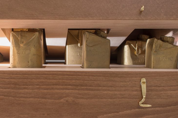 Objekte von Josephine Riemann (Detail): 8 Tetrapak-Verpackungen unterschiedlicher Größ,e in Messing abgegossen in einem Vollholzkasten.