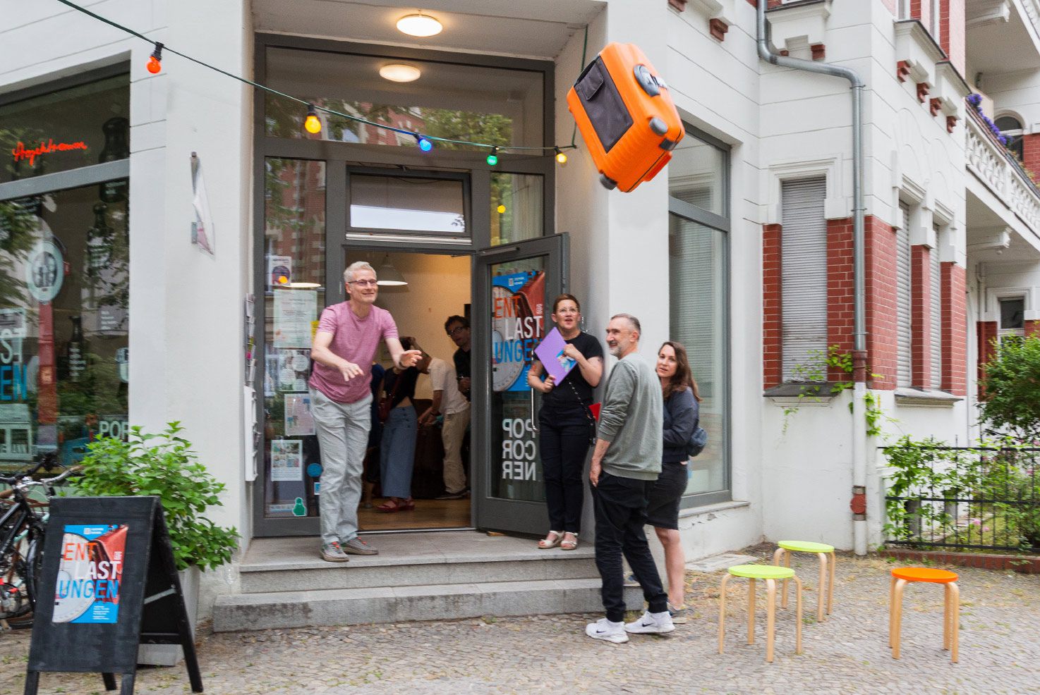 Kunst-Aktion von Josephine Riemann (Detail): Teilnehmer der Aktion ‚releasing‘ an der Station ‚werfen‘. Er wirft ein, von ihm gewähltes Gepäckstück, von einer Berliner Galerie auf die Straße.